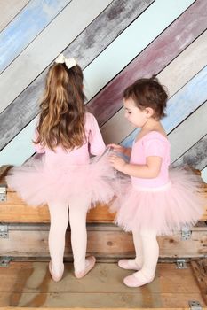 Friends playing dress-up in ballet costumes against colorful background