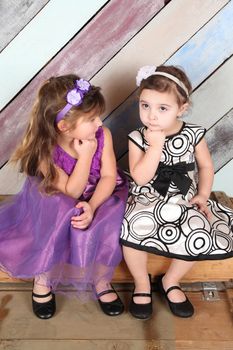 Brunette toddler friends against a colorful background