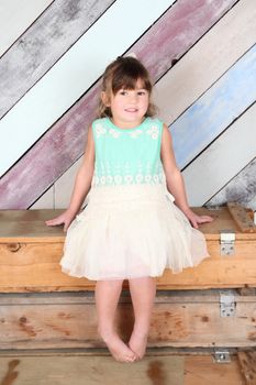 Brunette toddler girl against a colorful background