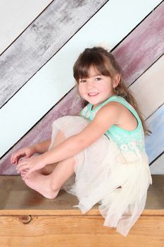 Brunette toddler girl against a colorful background