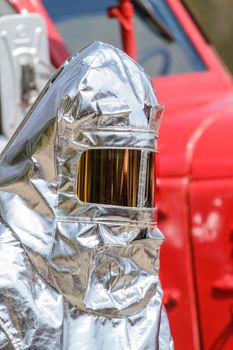 Fire in special heat resistant suit on a background of fire engine