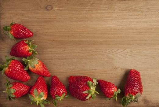 Ripe strawberries over wooden table background 