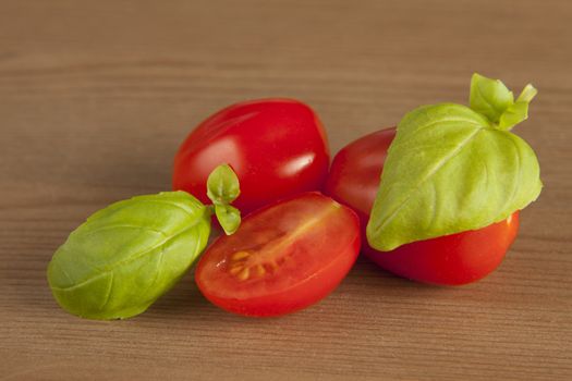 Cherry tomatoes and basil on wooden background