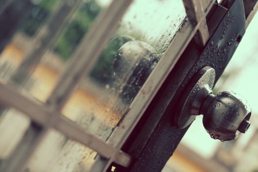 Rain drops on door handle and glass window in rainy day, drop of water falling make lonely feeling of cold day