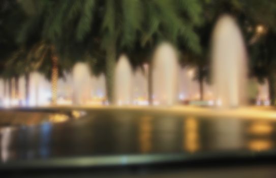 Blur blurred background street fountains, palm trees evening light for background