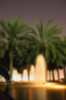 Blur blurred background street fountains, palm trees evening light for background