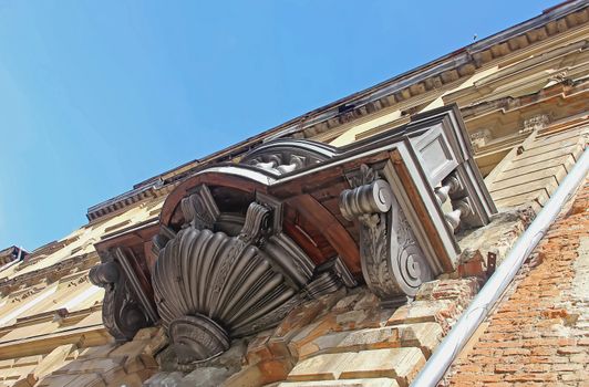 Sculpture balcony of the ancient architecture on the background of blue sky old brick building