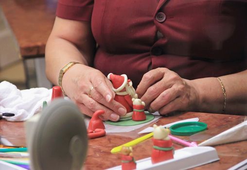 hand molded figures of marzipan modeling, preparation of sweet decorations for cakes and pies, women's hands, marzipan museum