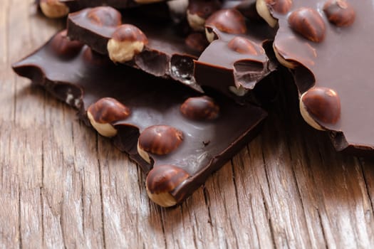 milk chocolate with hazelnuts on a wooden background