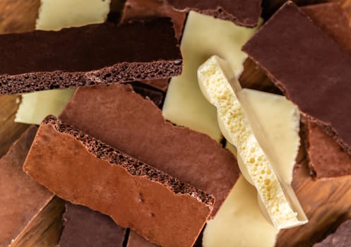 assortment porous chocolate close-up on a wooden background