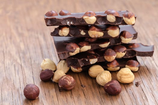 milk chocolate with hazelnuts on a wooden background