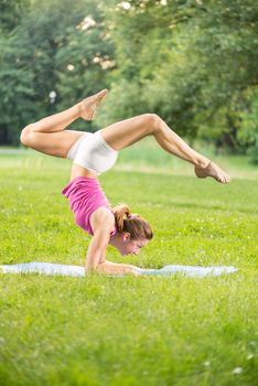 Cute young woman doing yoga in the park.