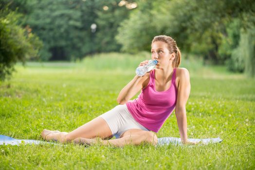 Beautiful young woman resting after exercising in the park.