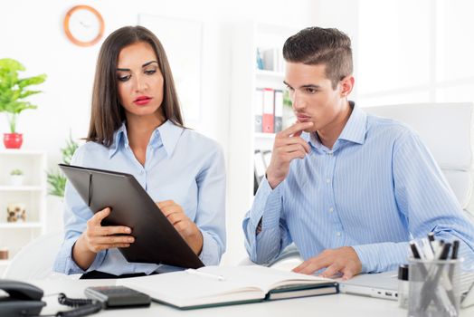 Young beautiful businesswoman and businessman working in the office.