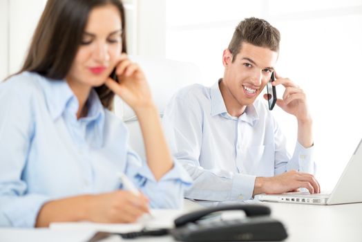 Young beautiful businessman telephoning in the office.