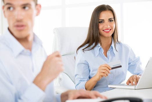 Young beautiful businesswomanholding credit card in the office