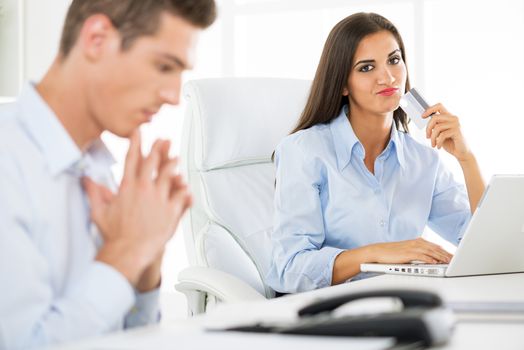 Young beautiful businesswomanholding credit card in the office