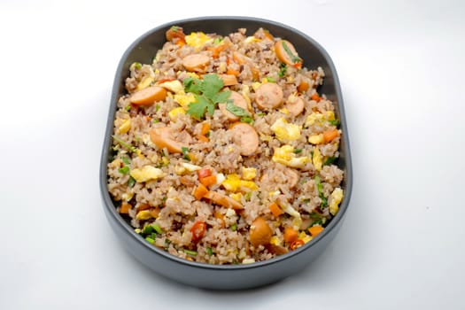 Fried rice with sausage and vegetables on white background