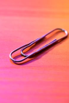Closeup of metal paper clip on colorful background