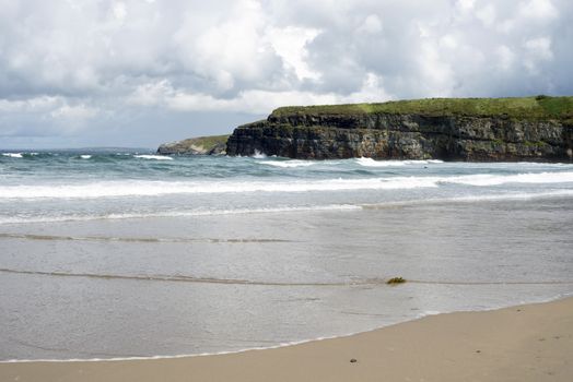 big waves rolling into the cliffs and beach in ballybunion on the wild atlantic way