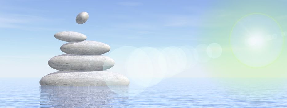 White stones in balance upon water by foggy day with sun