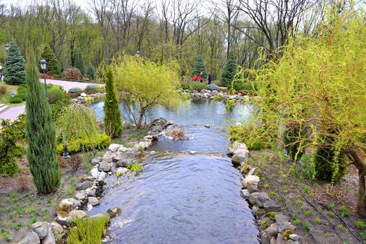 An artificial waterfall in a city park in early spring