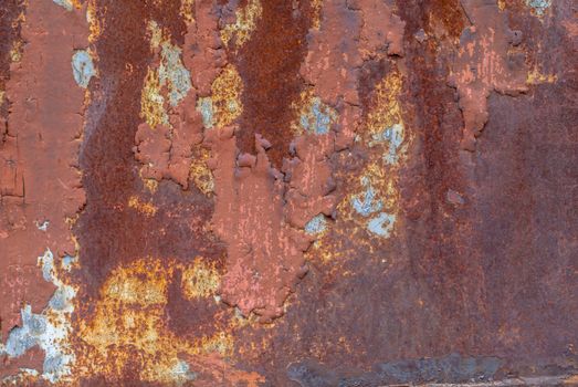 rusty iron surface covered with old chipped paint, which has long been influenced by different climatic conditions