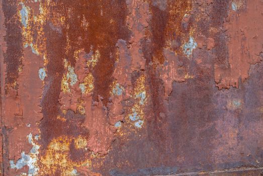 rusty iron surface covered with old chipped paint, which has long been influenced by different climatic conditions