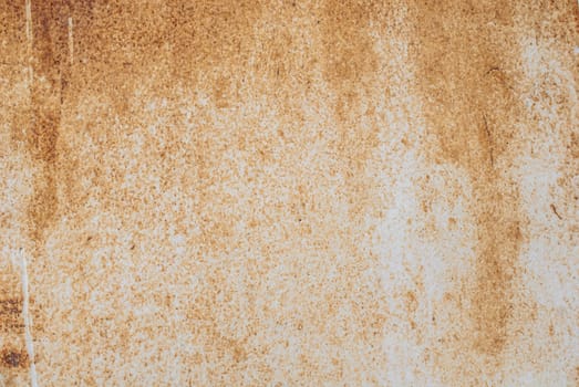 fragment of an iron surface is covered with beige color paint, which has long been under the influence of different climatic conditions
