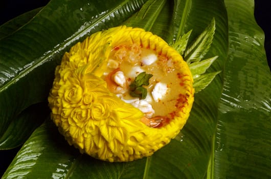 Thai shrimp spicy soup serve in bowl carved from pumpkin