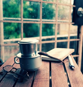 Coffee time in morning, relax moment in rainy day, coffee cup on cafe table with window background, slow life by enjoyment 