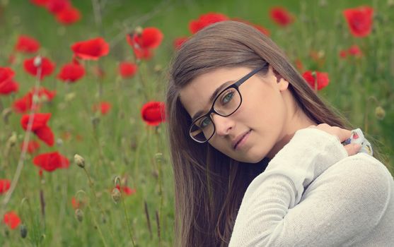 Portrait of young girl in poppy flowers field