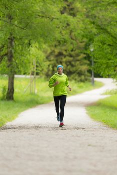 Sporty young female runner in city park.  Running woman. Female runner during outdoor workout in nature. Fitness model outdoors. Weight Loss. Healthy lifestyle. 