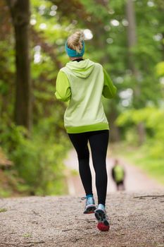 Sporty young female runner in forest.  Running woman. Female runner during outdoor workout in nature. Fitness model outdoors. Weight Loss. Healthy lifestyle. 