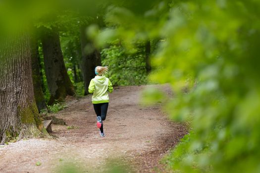 Sporty young female runner in forest.  Running woman. Female runner during outdoor workout in nature. Fitness model outdoors. Weight Loss. Healthy lifestyle. 