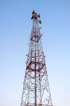 Telecommunications tower with clear blue sky.