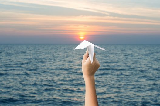 plane paper in children hands and sunset, forward to the target concept.