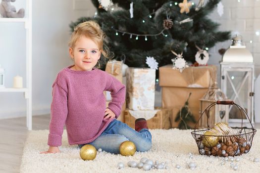 Beautiful Little girl waiting for a miracle in Christmas decorations