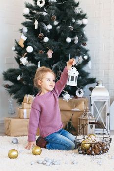 Beautiful Little girl waiting for a miracle in Christmas decorations