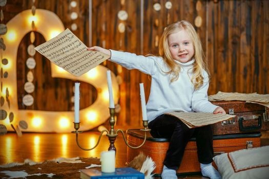 Blonde little girl holding a note in vintage interior