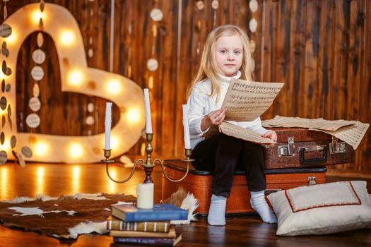 Blonde little girl holding a note in vintage interior