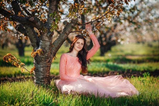 Portrait of a young beautiful girl in spring orchard