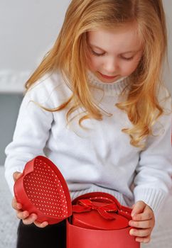 little girl opening red present