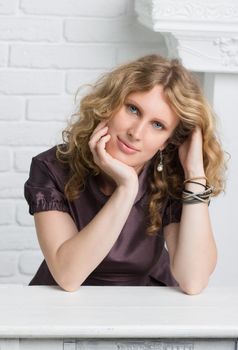 Portrait of a beautiful curly blonde pensive woman