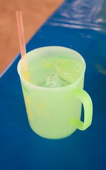 Green glass with ice Bright blue background