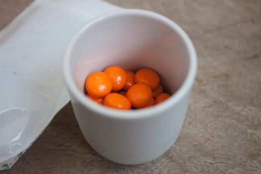 Orange pills in glass.