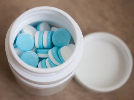 Paracetamol tablets, white and blue in the bottle cap.