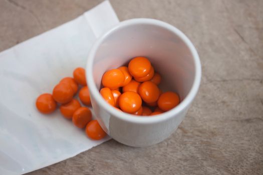 Orange pills in glass.