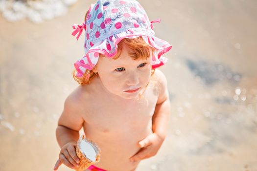 Cute little girl eating ice cream on beach vacation