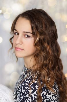 Close-up portrait of a pretty teenage girl with curly long hair